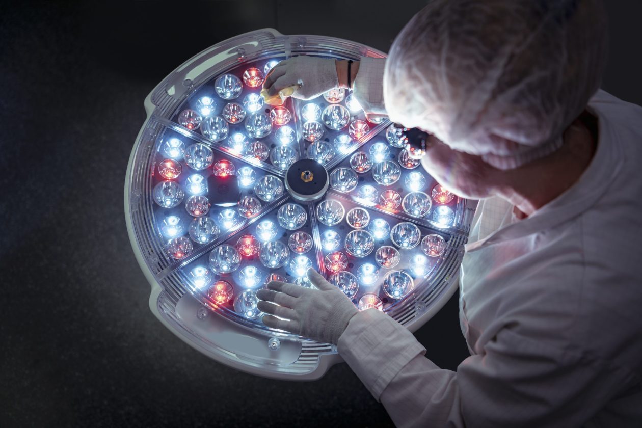 Female engineer preparing specialist operating theatre light in clean room in factory