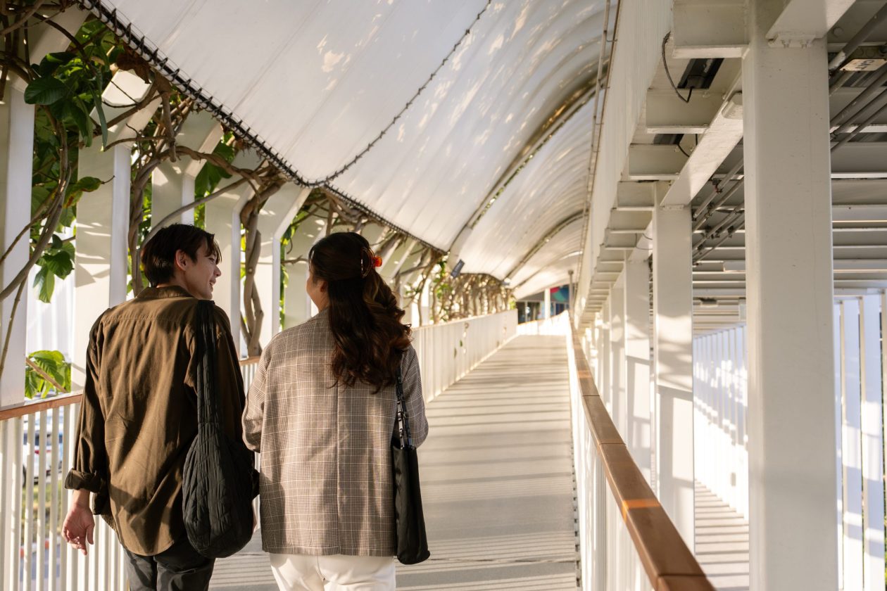 Asian professional employees enjoy talking after work while walking and leaving from office.