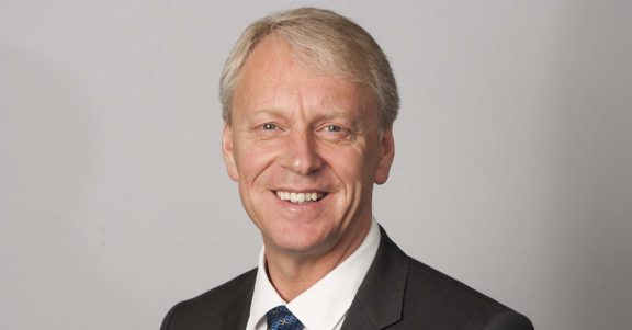 Picture of Chris Day in front of a gray background